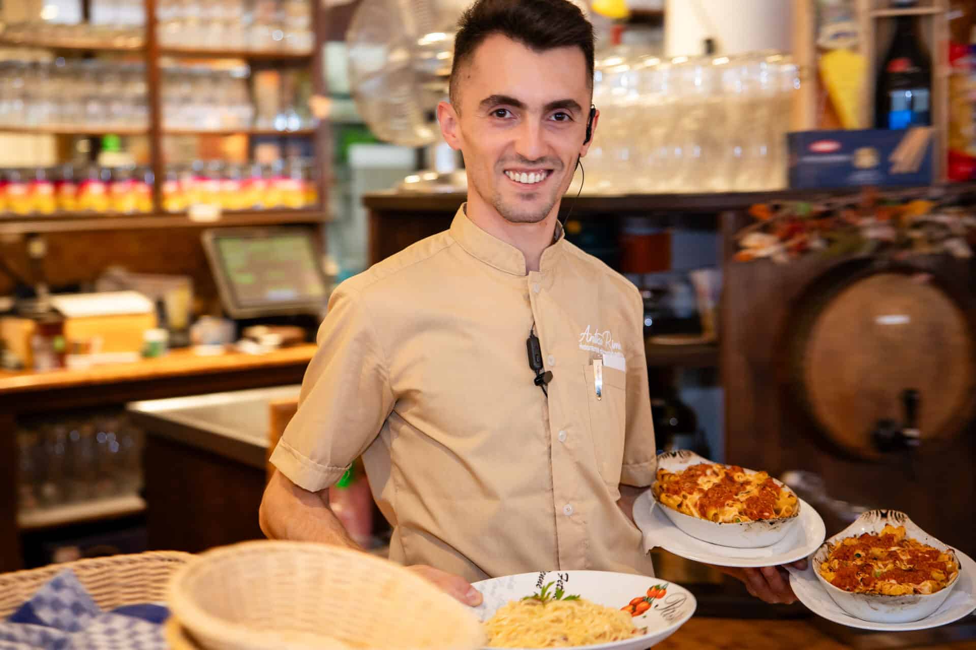 Servicekraft serviert frisch gebackene Pizza im Antica Rimini