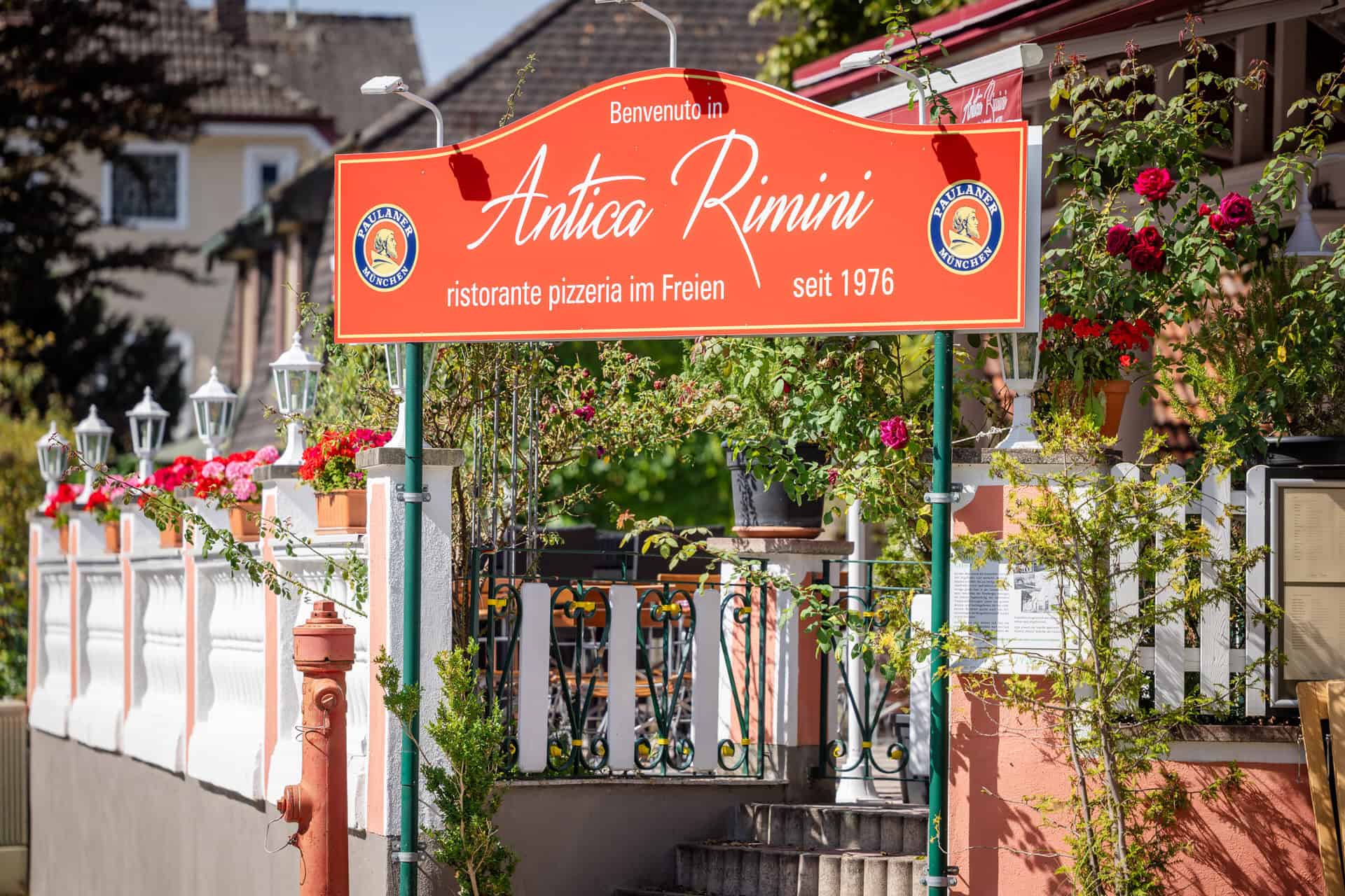 Eingang des Restaurants Antica Rimini in Penzberg mit Schild seit 1976